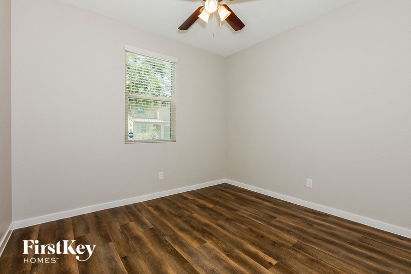 the living room of a home with wood floors and a ceiling fan