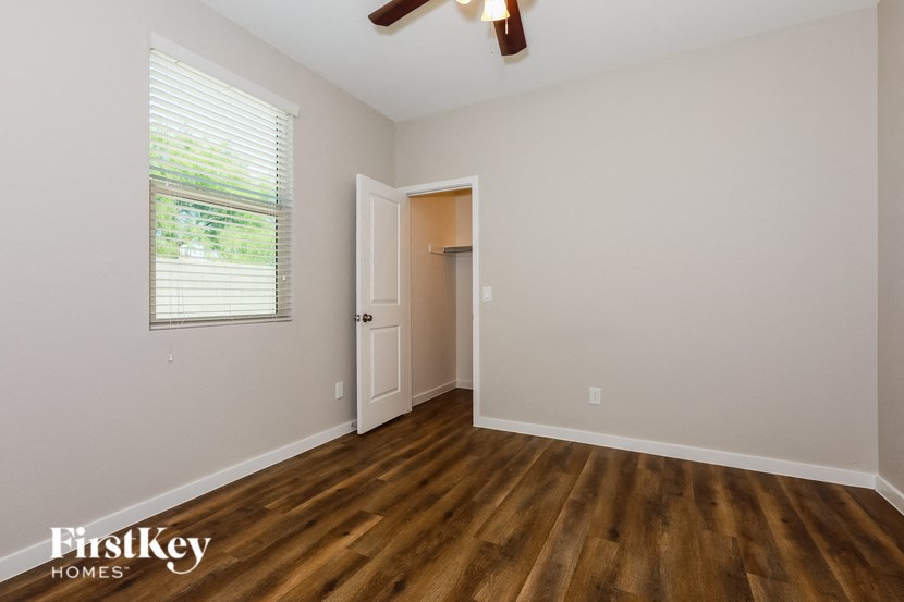 the living room of an empty house with wooden floors and a window