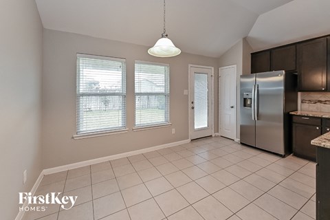 a kitchen with a stainless steel refrigerator and a sink and a door