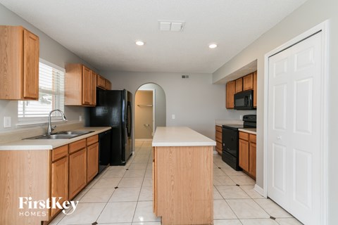 A kitchen with wooden cabinets and black appliances.