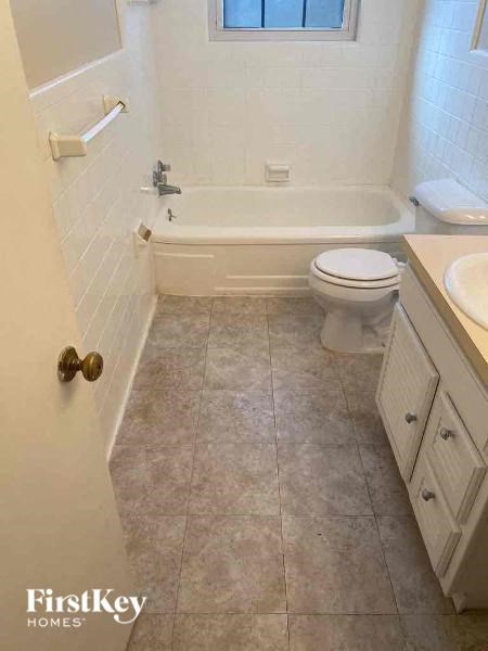 a bathroom with a toilet and a tub and a sink