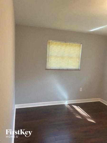 a empty room with a window and wooden floors