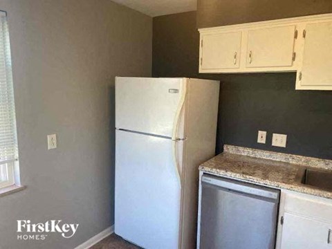 a kitchen with a white refrigerator and white cabinets