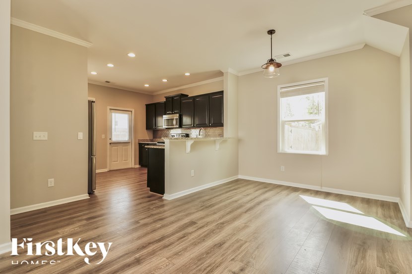A spacious kitchen with wooden floors and a modern design.