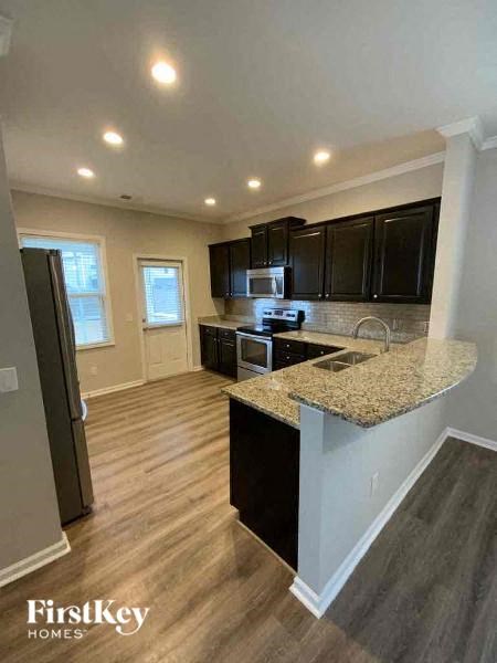 a kitchen with a granite counter top and black cabinets