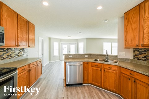 A kitchen with wooden cabinets and a stainless steel dishwasher.