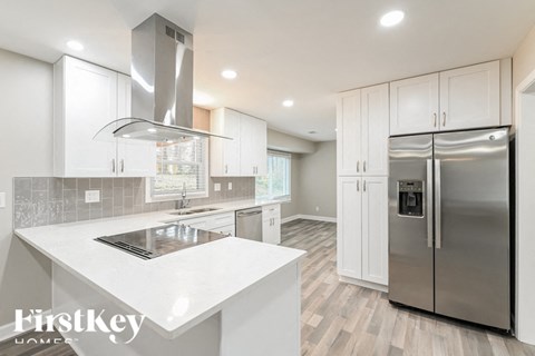 A modern kitchen with a stainless steel refrigerator and a white countertop.