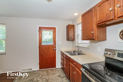 A kitchen with wooden cabinets and a stove top oven.