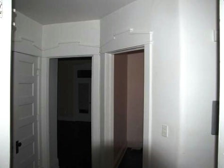a white room with a door open and a hallway