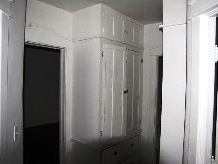 a white cabinet in a room with a door