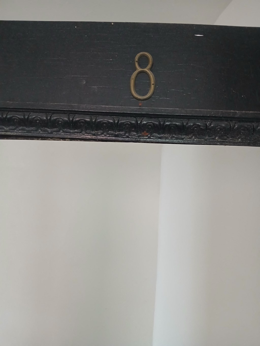 a black dresser with a gold number 8 on it