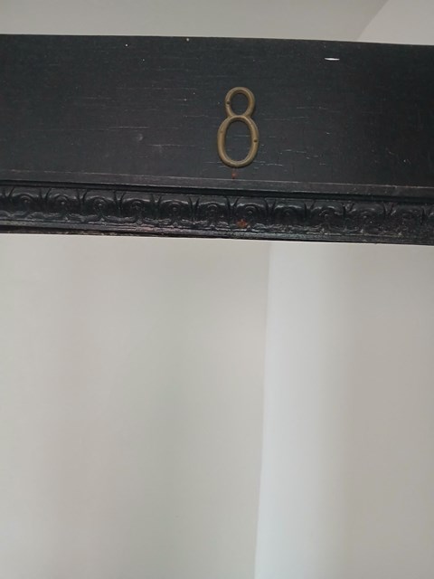 a black dresser with a gold number 8 on it