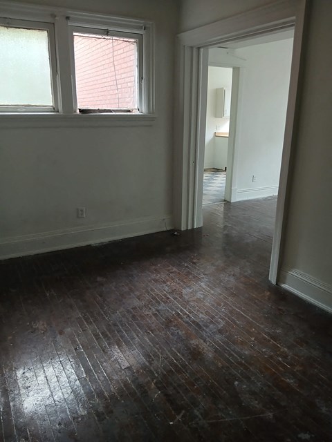 a living room with a hard wood floor and a window