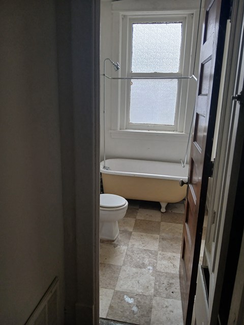 a bathroom with a tub and a toilet and a window