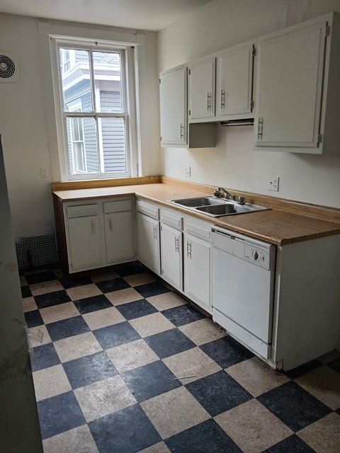 an empty kitchen with a sink and a window