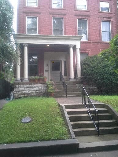 a brick house with columns and stairs in front of it