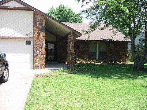 the front of a house with a lawn and a driveway