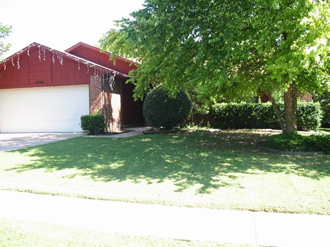 a house with a lawn and a tree in front of it