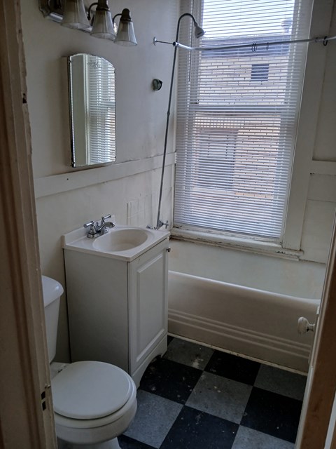 a small bathroom with a sink toilet and bath tub