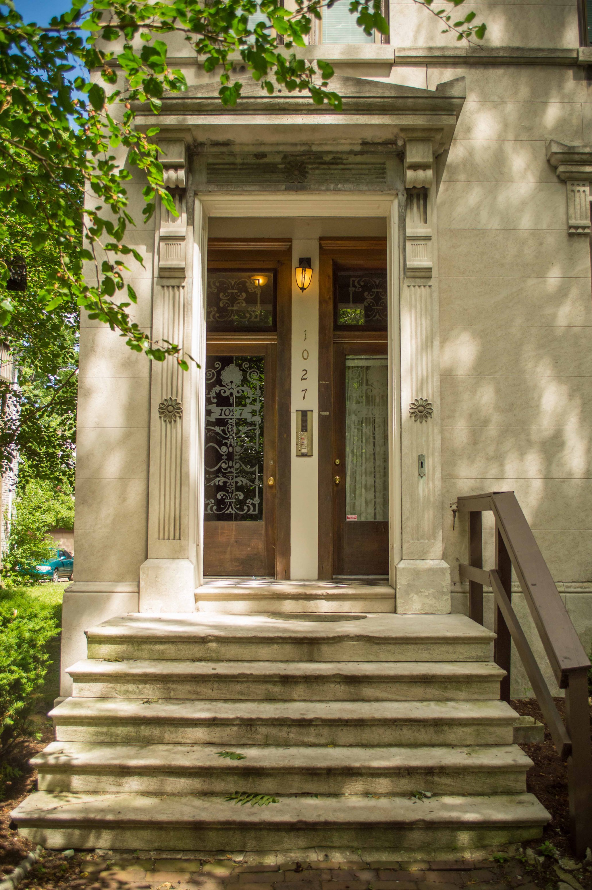 the front of a house with stairs and a door