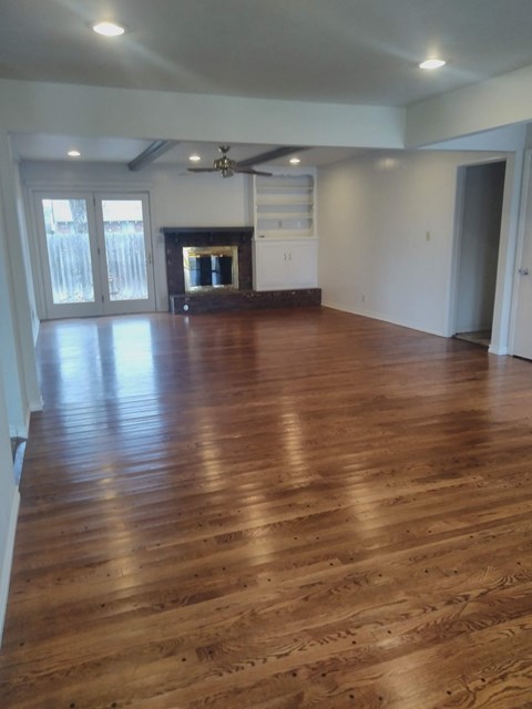 an empty living room with wooden floors and a fireplace