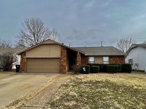 a brown brick house with a brown garage door