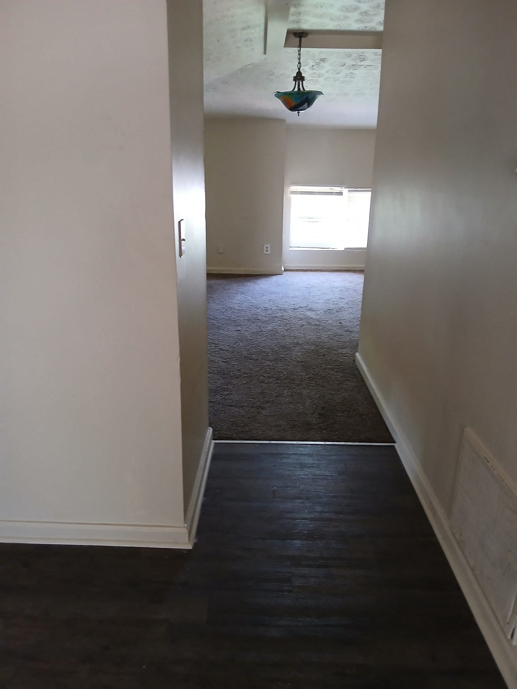 an empty room with a wood floor and white walls