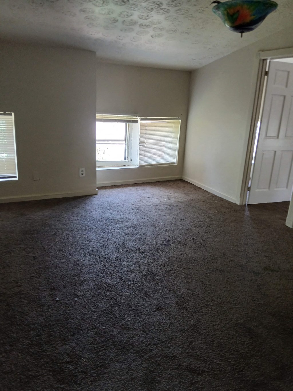 an empty living room with a window and a door