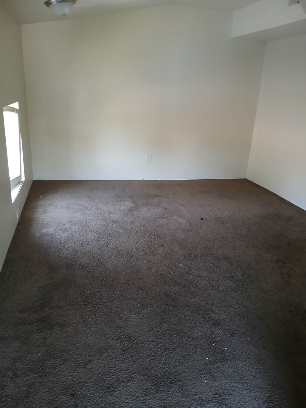 an empty room with carpet and a window