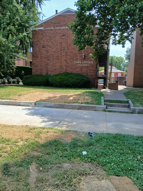 an empty sidewalk in front of a brick building