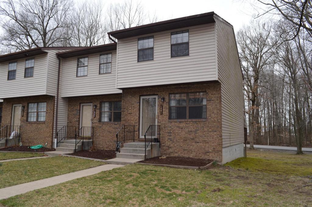 A two-story house with a front porch and a small front yard.