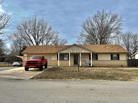 a house with a red truck parked in front of it
