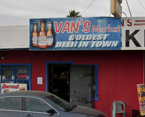 A red building with a sign that says "Van's Market" and "Coldest Beer in Town."