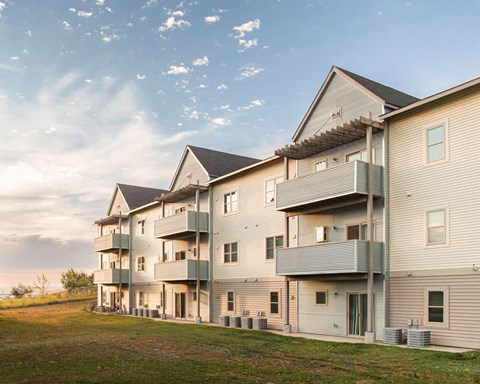 a row of houses with balconies on the side of a field