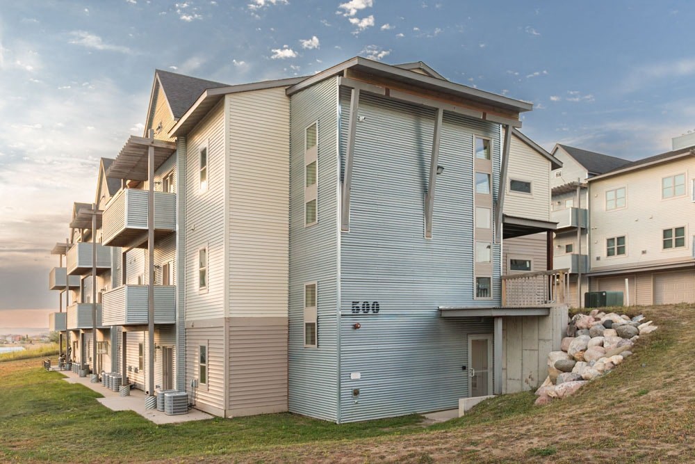 a row of condos with balconies on the side of a hill