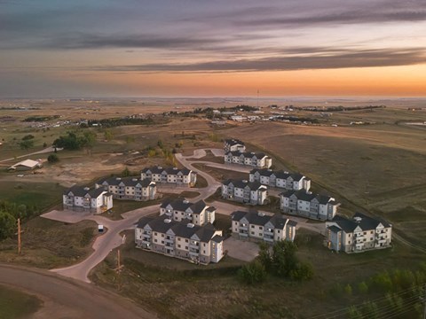 an aerial view of a subdivision with houses and a sunset