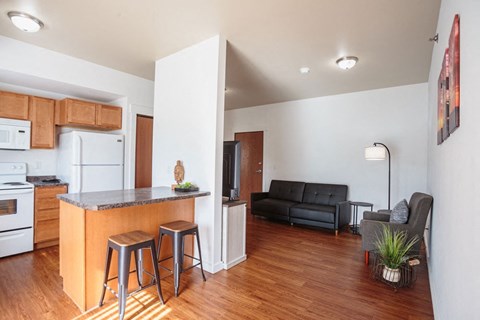 a kitchen with a bar and a living room with a couch