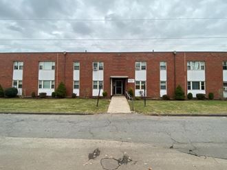 an old brick building with a sidewalk in front of it