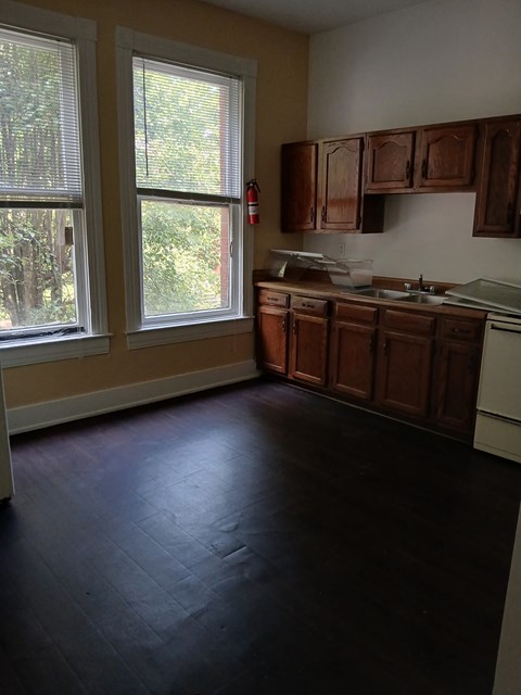 A kitchen with wooden cabinets and a white dishwasher.