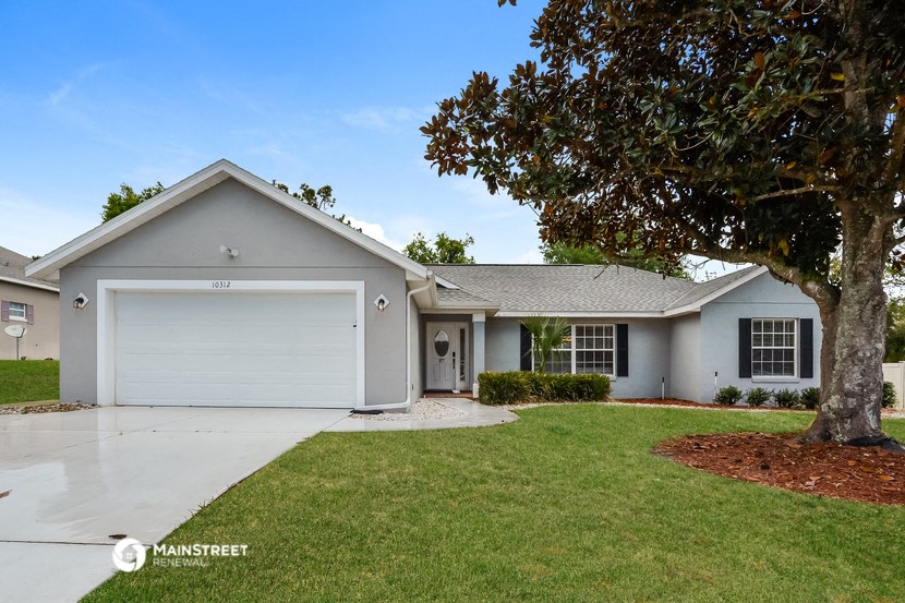 a white house with a yard and a tree