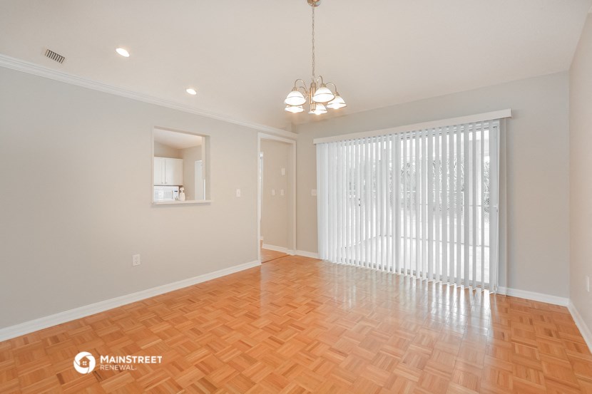 a living room and dining room with wood flooring and a large window