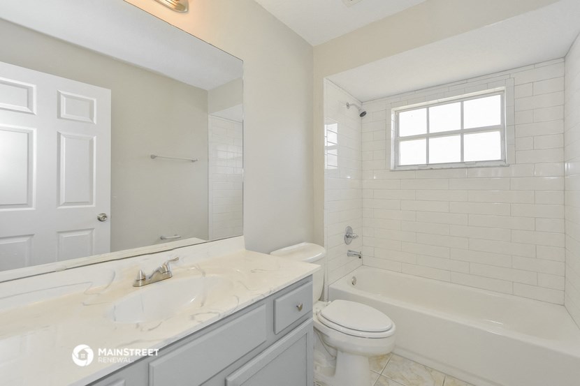 a white bathroom with a sink and a toilet and a tub
