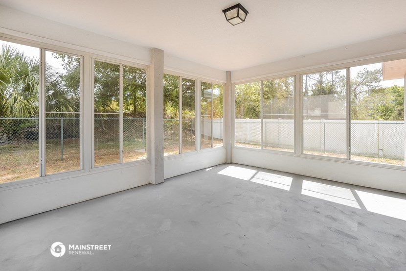 an empty living room with large windows and a balcony