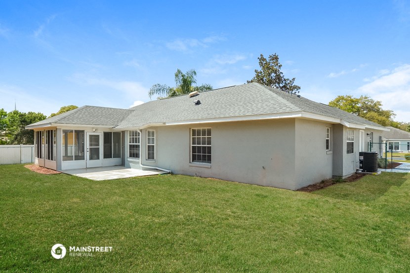 a white house with a grassy yard and a patio