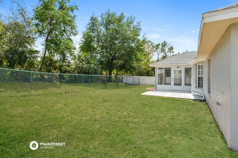 a backyard with a chain link fence and a house