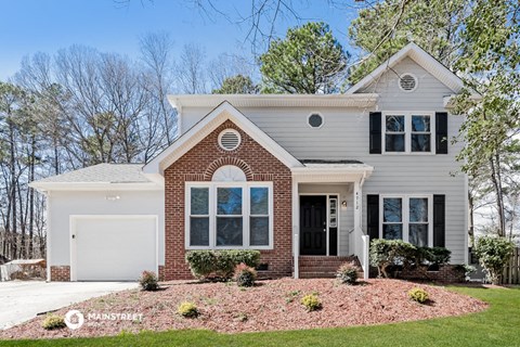 a white house with a front yard and a white garage door