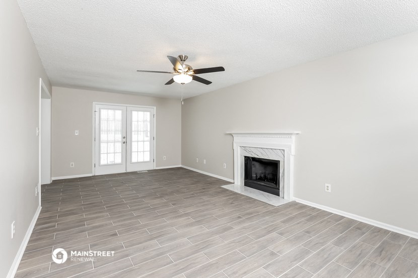the living room with fireplace and ceiling fan