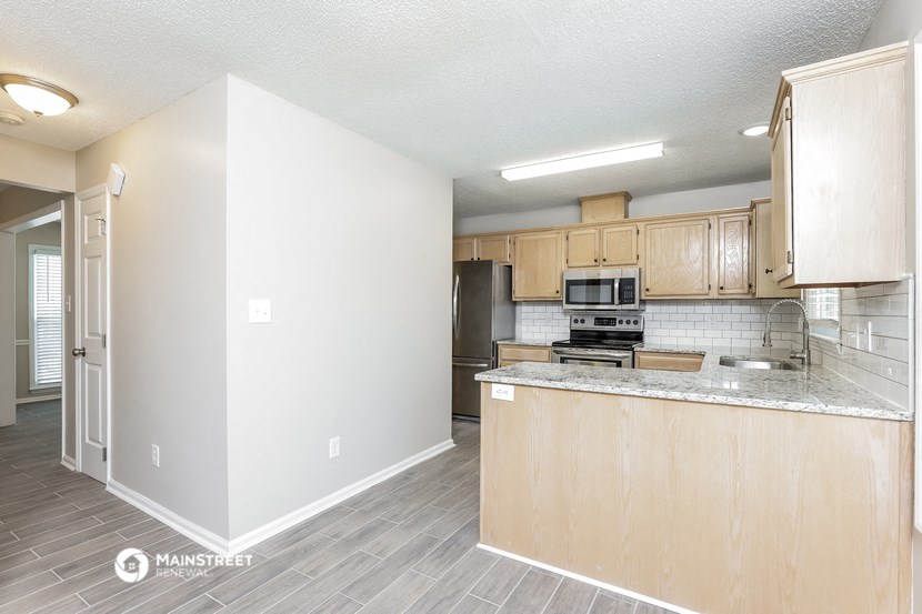 an empty kitchen with wooden cabinets and a counter top