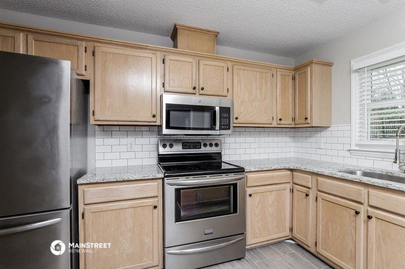 a kitchen with wooden cabinets and stainless steel appliances