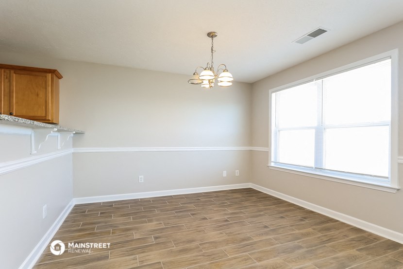 an empty living room with wood flooring and a large window